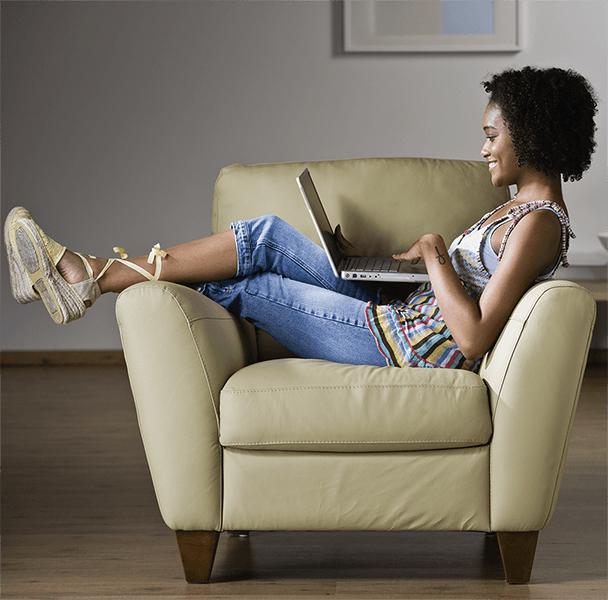 woman relaxing on armchair with a laptop